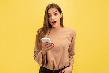 Image showing Portrait of young caucasian woman with bright emotions isolated on yellow studio background