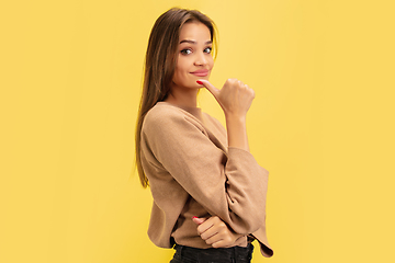 Image showing Portrait of young caucasian woman with bright emotions isolated on yellow studio background