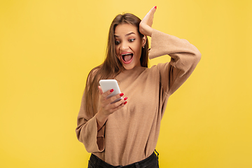 Image showing Portrait of young caucasian woman with bright emotions isolated on yellow studio background