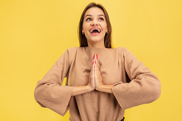 Image showing Portrait of young caucasian woman with bright emotions isolated on yellow studio background