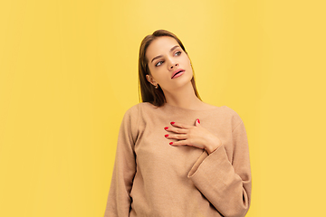 Image showing Portrait of young caucasian woman with bright emotions isolated on yellow studio background