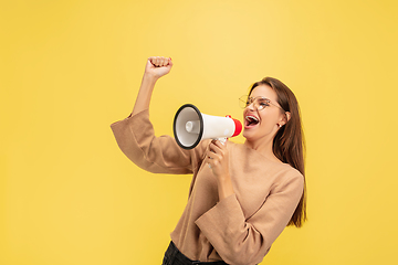 Image showing Portrait of young caucasian woman with bright emotions isolated on yellow studio background