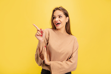 Image showing Portrait of young caucasian woman with bright emotions isolated on yellow studio background