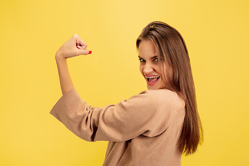 Image showing Portrait of young caucasian woman with bright emotions isolated on yellow studio background