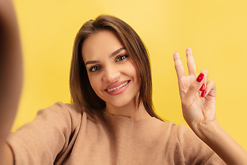 Image showing Portrait of young caucasian woman with bright emotions isolated on yellow studio background