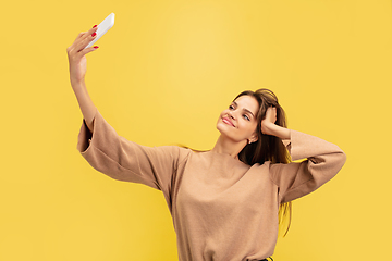 Image showing Portrait of young caucasian woman with bright emotions isolated on yellow studio background