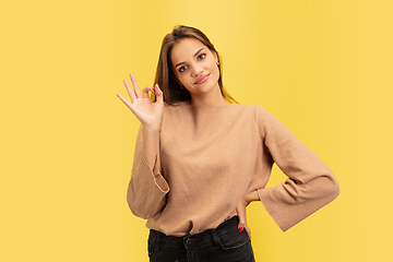 Image showing Portrait of young caucasian woman with bright emotions isolated on yellow studio background