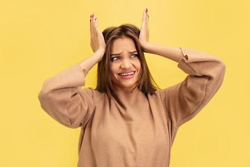 Image showing Portrait of young caucasian woman with bright emotions isolated on yellow studio background