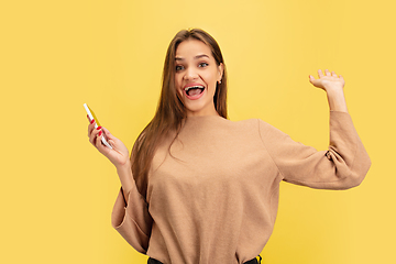 Image showing Portrait of young caucasian woman with bright emotions isolated on yellow studio background