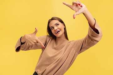 Image showing Portrait of young caucasian woman with bright emotions isolated on yellow studio background