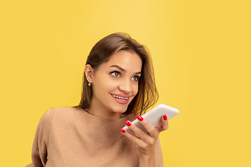 Image showing Portrait of young caucasian woman with bright emotions isolated on yellow studio background