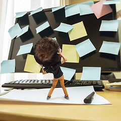 Image showing Tired man, office worker holding his huge tired head, funny