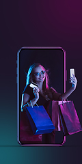 Image showing Beautiful woman inviting for shopping right from device screen, black friday, sales concept. Flyer with copyspace