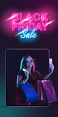 Image showing Beautiful woman inviting for shopping right from device screen, black friday, sales concept. Flyer with copyspace