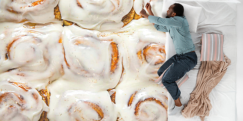 Image showing Portrait of a young man sleeping and dreaming about buns and cookie