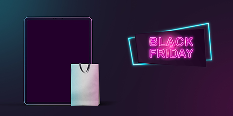 Image showing Device with shopping bags, black friday, sales concept. Flyer with copyspace. Dark neoned background