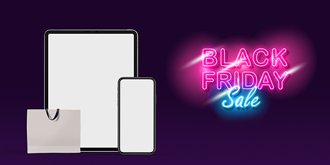 Image showing Device with shopping bags, black friday, sales concept. Flyer with copyspace. Dark neoned background