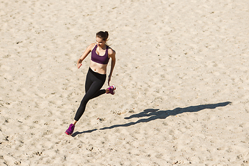 Image showing Young woman training outdoors in autumn sunshine. Concept of sport, healthy lifestyle, movement, activity.