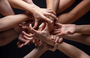 Image showing Hands of people\'s crowd in touch isolated on black studio background. Concept of human relation, community, togetherness, symbolism