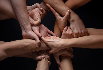 Image showing Hands of people\'s crowd in touch isolated on black studio background. Concept of human relation, community, togetherness, symbolism