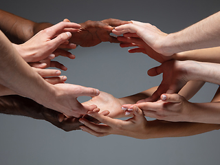 Image showing Hands of people\'s crowd in touch isolated on grey studio background. Concept of human relation, community, togetherness, symbolism