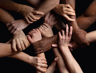 Image showing Hands of people\'s crowd in touch isolated on black studio background. Concept of human relation, community, togetherness, symbolism