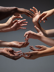 Image showing Hands of people\'s crowd in touch isolated on grey studio background. Concept of human relation, community, togetherness, symbolism