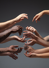 Image showing Hands of people\'s crowd in touch isolated on grey studio background. Concept of human relation, community, togetherness, symbolism