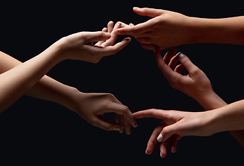 Image showing Hands of people\'s crowd in touch isolated on black studio background. Concept of human relation, community, togetherness, symbolism