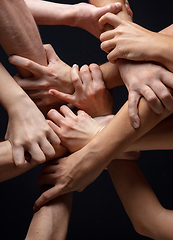 Image showing Hands of people\'s crowd in touch isolated on black studio background. Concept of human relation, community, togetherness, symbolism