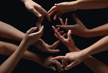 Image showing Hands of people\'s crowd in touch isolated on black studio background. Concept of human relation, community, togetherness, symbolism