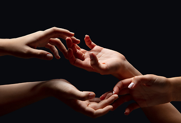 Image showing Hands of people\'s crowd in touch isolated on black studio background. Concept of human relation, community, togetherness, symbolism