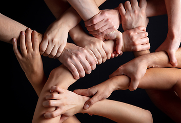 Image showing Hands of people\'s crowd in touch isolated on black studio background. Concept of human relation, community, togetherness, symbolism