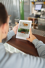 Image showing Remote working. Workplace in bar, restaurant office with PC, devices and gadgets.