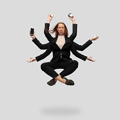 Image showing Beautiful business woman, secretary, multi-armed manager levitating isolated on grey studio background