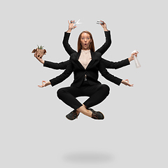 Image showing Beautiful business woman, secretary, multi-armed manager levitating isolated on grey studio background