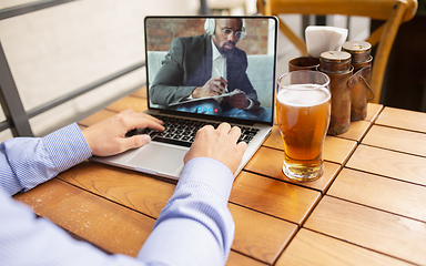 Image showing Remote working, online entertainment during quarantine. Remote events in bar, restaurant office with PC, devices and gadgets.