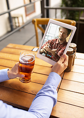 Image showing Remote working, online entertainment during quarantine. Remote events in bar, restaurant office with PC, devices and gadgets.