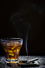 Image showing Glass of cold drink and tobacco