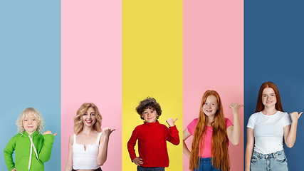 Image showing Young people pointing at sides on multicolored background. Human emotions, facial expression concept. Trendy colors. Creative collage.