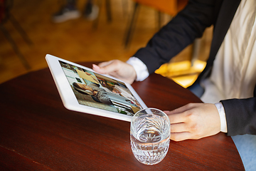 Image showing Remote working. Workplace in bar, restaurant office with PC, devices and gadgets.