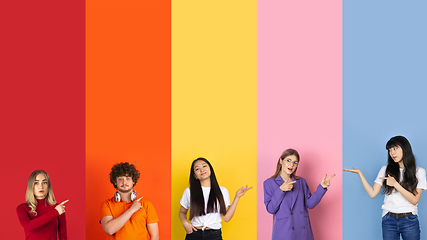 Image showing Young people pointing at sides on multicolored background. Human emotions, facial expression concept. Trendy colors. Creative collage.