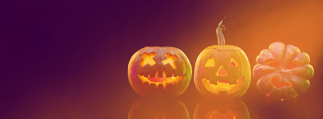 Image showing Scary pumpkins on dark orange background, the night of fear