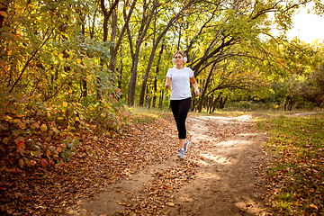 Image showing Disabled woman walking down and training outdoors in forest