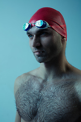 Image showing Professional male swimmer with hat and goggles in motion and action, healthy lifestyle and movement concept. Neoned style.