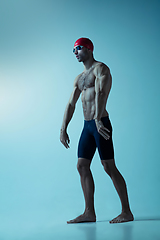 Image showing Professional male swimmer with hat and goggles in motion and action, healthy lifestyle and movement concept. Neoned style.