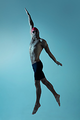 Image showing Professional male swimmer with hat and goggles in motion and action, healthy lifestyle and movement concept. Neoned style.