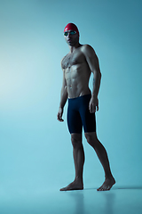 Image showing Professional male swimmer with hat and goggles in motion and action, healthy lifestyle and movement concept. Neoned style.