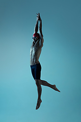 Image showing Professional male swimmer with hat and goggles in motion and action, healthy lifestyle and movement concept. Neoned style.