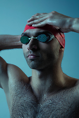 Image showing Professional male swimmer with hat and goggles in motion and action, healthy lifestyle and movement concept. Neoned style.